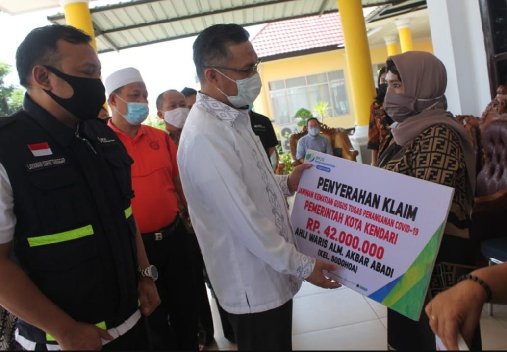Retnowati saat menerima klaim asuransi relawan COVID-19 untuk suaminya yang meninggal dunia. Foto: Dok. kendarikota.go.id
