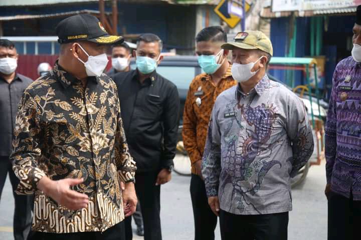 Kepala Dinas Sosial Kota Kendari, Abdul Rauf (kanan) saat bersama Menko PMK, Muhadjir Effendy melakukan pembagian paket sembako di Kelurahan Sodohoa. Foto: Ist.
