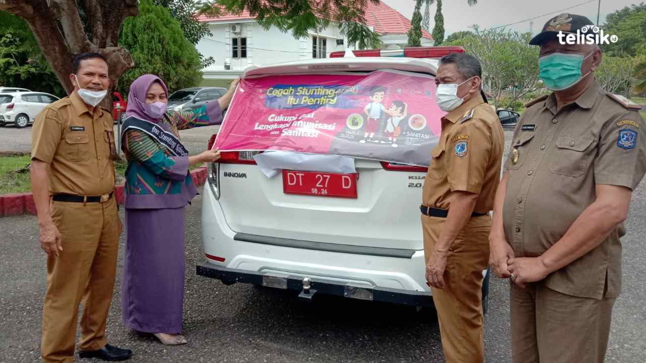Wabup Muna, Bachrun Labuta bersama Ketua TP PKK Muna, Yanti Setiawati Rusman memasang stikir pencegahan stunting. Foto: Sunaryo/Telisik