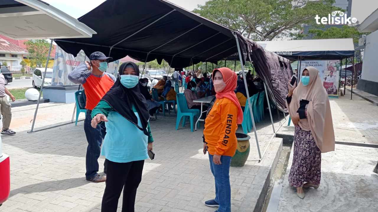 Sekda Kota Kendari (baju oranye) bersama Kadis Kesehatan (baju biru) menyiapkan kedatangan lokasi vaksin di Dinas Kesehatan terkait kunjungan kerja Mendagri. Foto: Sumarlin/Telisik