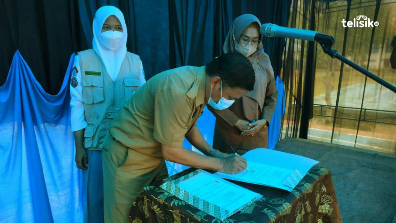 Kepala SMAN 3 Bombana, Yakob Simson bersama Kadis DP3A Bombana saat menandatangai nota kesepahaman Sekolah Ramah Anak. Foto: Hir/Telisik.