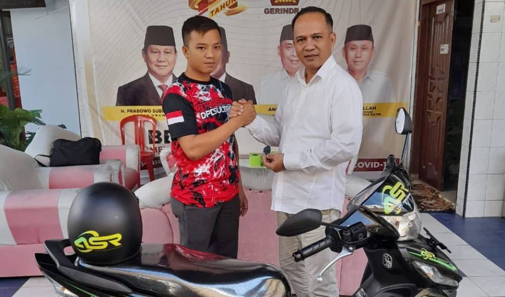 Bendahara Umum DPD Gerindra Sultra, Andi Agus Cahyadi (kanan) menyerahkan hadiah motor pada Wakil Ketua PAC Gerindra Palangga. Foto: Ist.