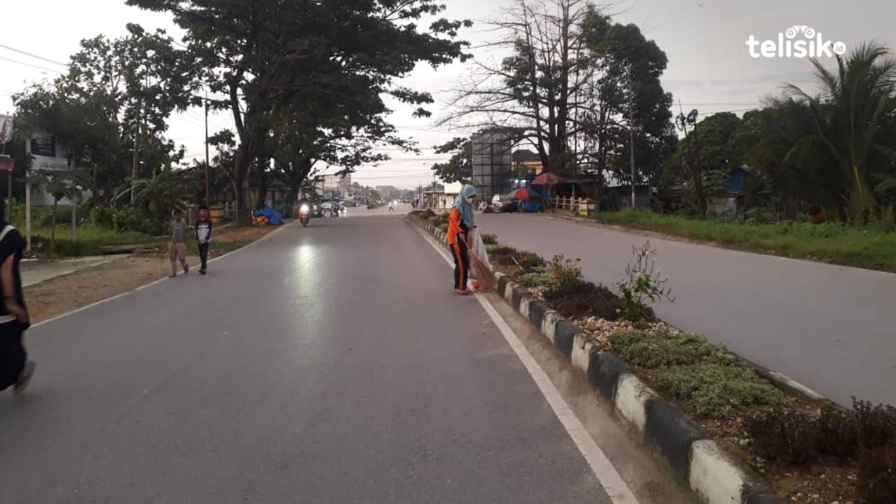 Seorang petugas kebersihan yang sedang membersihkan  Jalan Sorumba. Foto: Aris Mantobua/Telisik