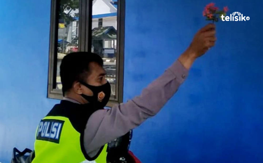 Salah seorang Polantas melakukan ritual di Pos Lantas yang baru dibangun guna mencegah agar pos tersebut tidak dibakar lagi. Foto: Thamrin Dalby/Telisik