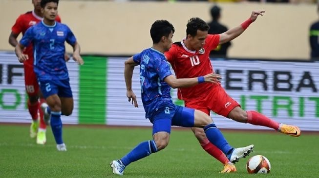 Pesepak bola Timnas Indonesia Egy Maulana Vikri (kanan) berebut bola dengan pesepak bola Timnas Thailand Airfan Doloh dalam pertandingan semifinal sepak bola SEA Games 2021 Vietnam di Stadion Thien Truong, Nam Dinh, Vietnam, Kamis (19/5/2022). Foto: Repro