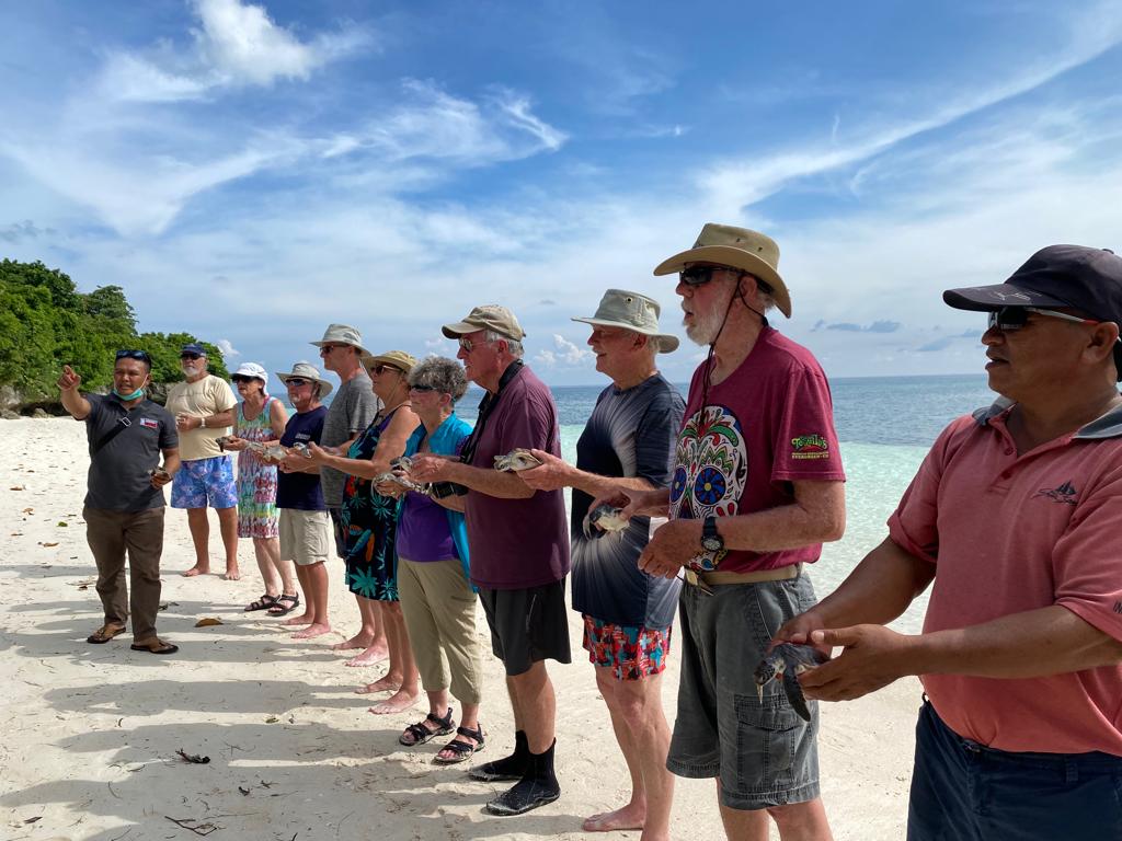 Rombongan wisatawan mancanegara bersama staff SPTN III Tomia-Binongko, Kelompok Pencinta Alam Toburi Tomia dan crew kapal LOB Seven Seas melapasliarkan tukik di Pantai Hondue Wakatobi Foto: Ist.