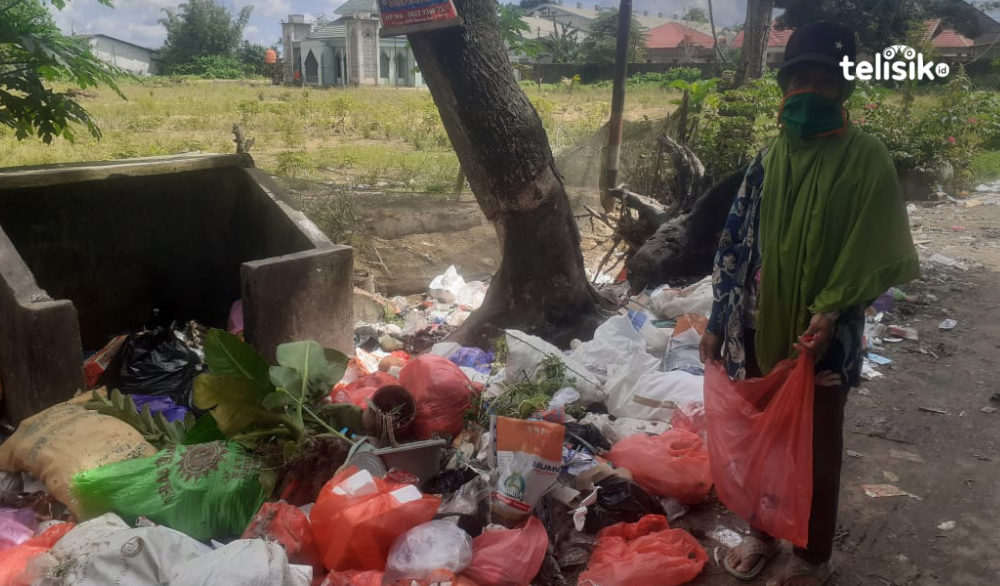 Siti Aminah mencari plastik bekas di antara tumpukan sampah. Foto: Ridho Syafarullah/Telisik