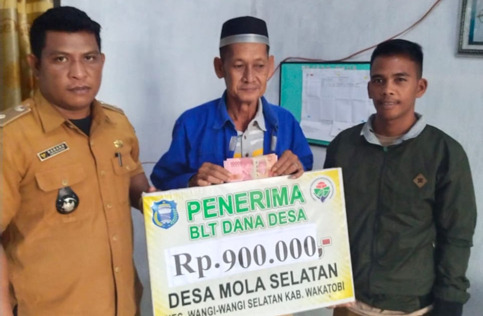 Diguyur Hujan, BLT-DD Dibagikan Door to Door  WAKATOBI, TELISIK.ID - Hujan yang mengguyur Kabupaten Wakatobi selama hampir 20 hari, tidak menyurutkan langkah Pemerintah Desa (Pemdes) Mola Selatan, Kabupaten Wakatobi, Sulawesi Tenggara, untuk menyalurkan B