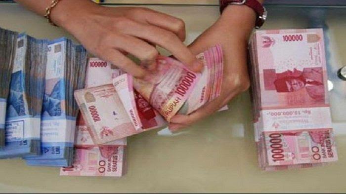 Seorang pegawai bank sedang menghitung pencairan gaji ke-13 para ASN. Foto: Repro tribunnews.com