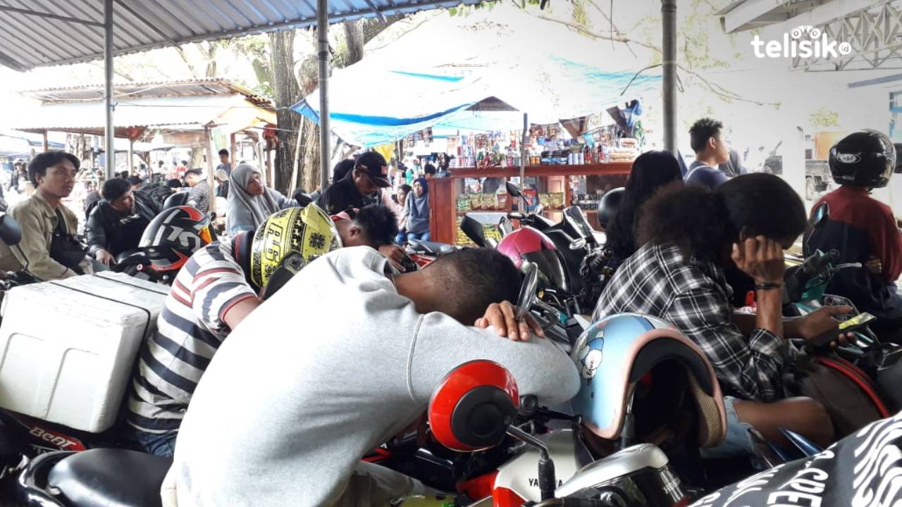 Sejumlah penumpang harus tidur di atas motor saat mengantre untuk masuk dalam kapal feri. Foto: Aris Mantobua/Telisik