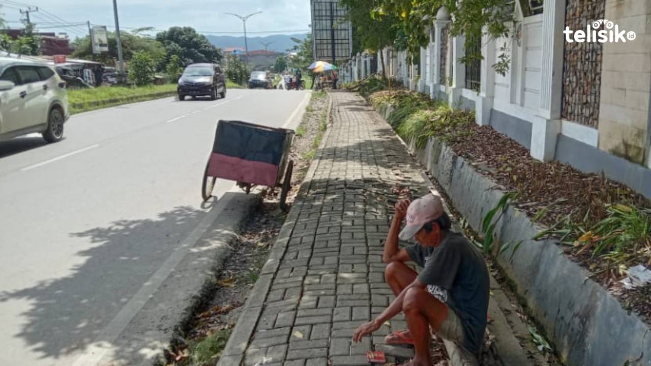 Burhan sedang duduk beristirahat di trotoar, sebelum melanjutkan bekerja mencari botol plastik bekas. Foto. La Ode Muh Martoton/Telisik