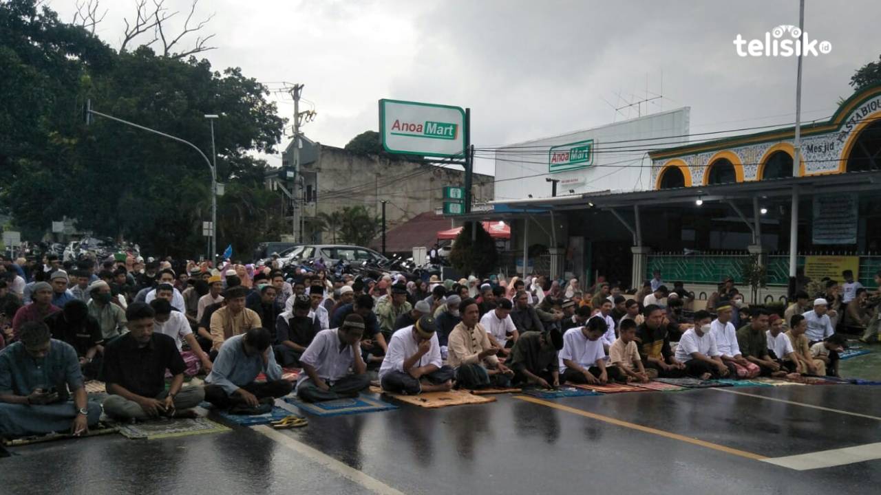 Warga Kelurahan Watu-Watu tetap antusias melaksanakan salat Idul Adha hingga di poros jalan Mayjend Soetoyo meskipun diguyur hujan. Foto: Thamrin Dalby/Telisik