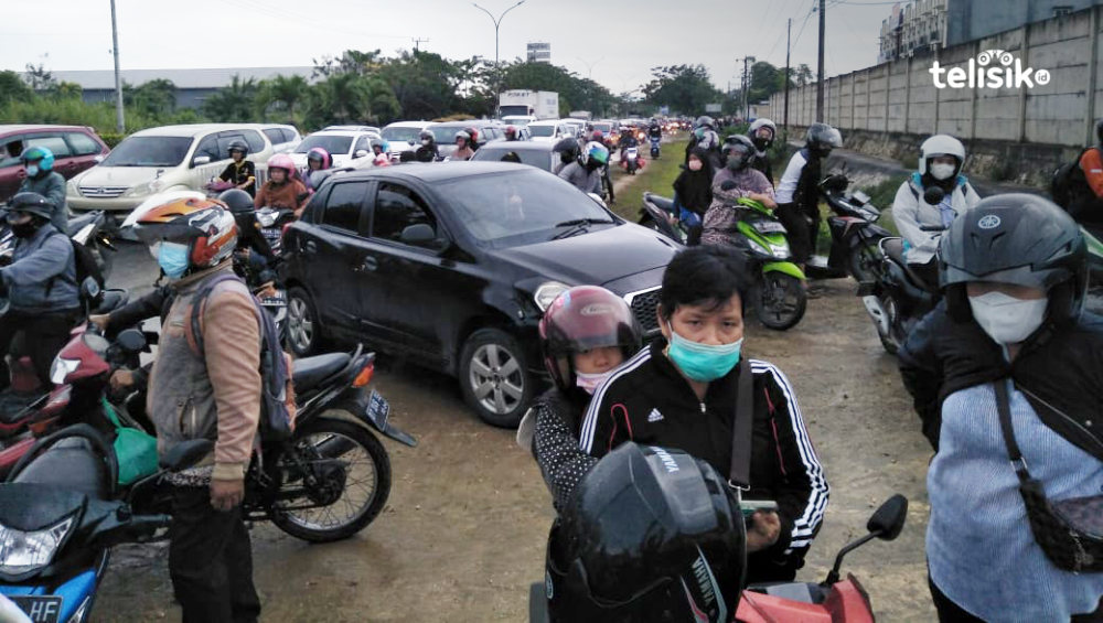 Ratusan kendaraan roda dua menunggu banjir di poros By Pass Jalan Brigjend M Yoenoes Kelurahan Lepo-lepo, surut. Foto: Thamrin Dalby/Telisik