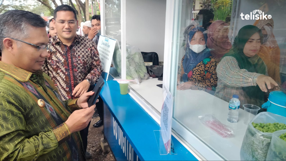 Wali Kota Kendari, Sulkarnain Kadir saat melakukan transaksi pembayaran digital usia membeli kebutuhan pokok di pasar tani yang terletak di halaman Dinas Pertanian Kota Kendari. Foto: Muhammad Ilwanto/Telisik