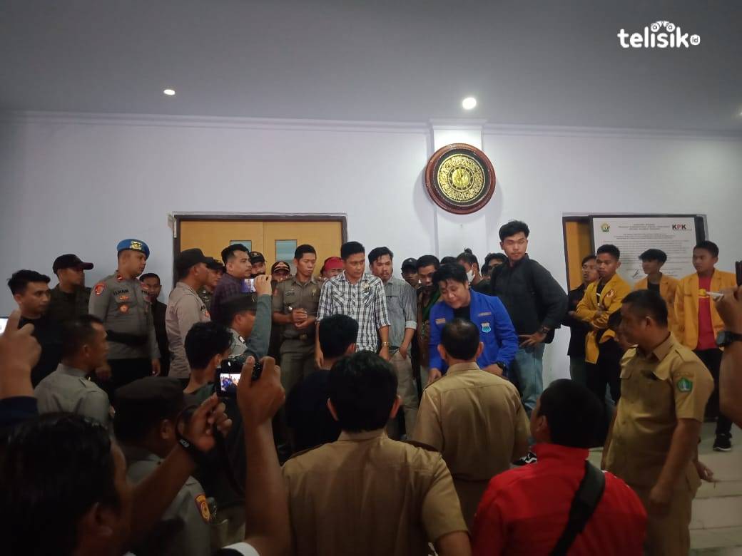Diskusi alot antara staf Sekertariat DPRD, anggota fraksi Demokrat,  dengan perwakilan mahasiswa di depan ruang sidang paripurna terkait keinginan mereka menduduki ruangan tersebut. Foto: Muh. Risal H/Telisik