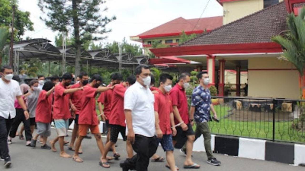 Pelaku (baju merah) yang terlibat dengan perjudian online di Provinsi Sumatera Utara yang telah ditetapkan sebagai tersangka ketika diamankan petugas kepolisian. Foto: Humas Polda Sumatera Utara