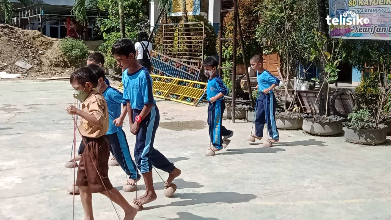 Murid SD Pancasila Kendari bermain permainan tradisional egrang batok dalam gelar karya kearifan lokal. Foto: Wa Ode Ria Ika Hasana/Telisik