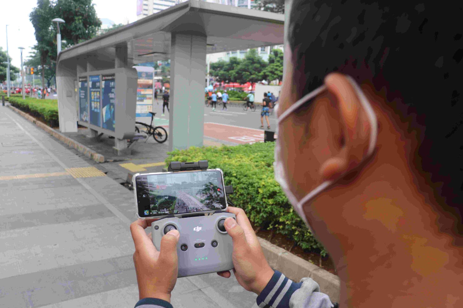Salah satu petugas Dinas Lingkungan Hidup DKI Jakarta menggunakan drone untuk memantau pelanggar pembuang sampah sembarangan di salah satu lokasi Car Free Day sekitar Jalan Thamrin-Sudirman. Foto: Ist.