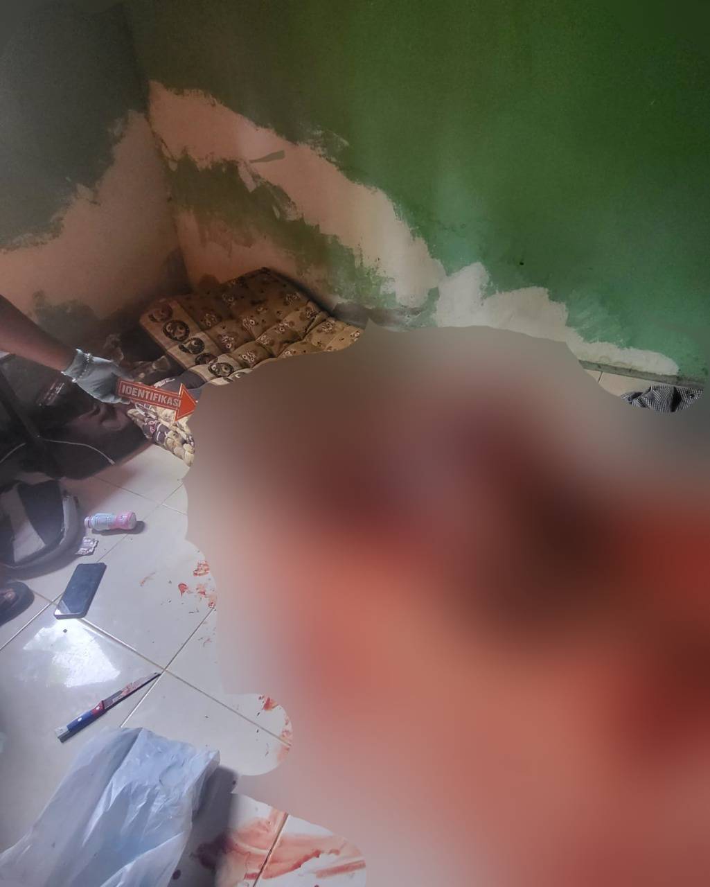 Genangan darah yang mengucur hingga keluar kamar, menjadi awal dari penemuan sesosok mayat di kamar kos. Hingga kini misteri penyebabnya masih belum diketahui. Foto: Ist.