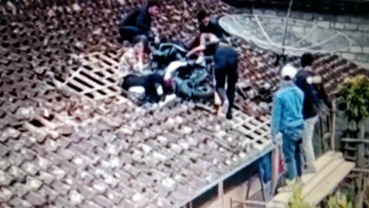 Sebuah video yang menunjukan sepeda motor menyangkut di atas rumah warga di Magelang viral di media sosial. Foto: Inewsjateng.id