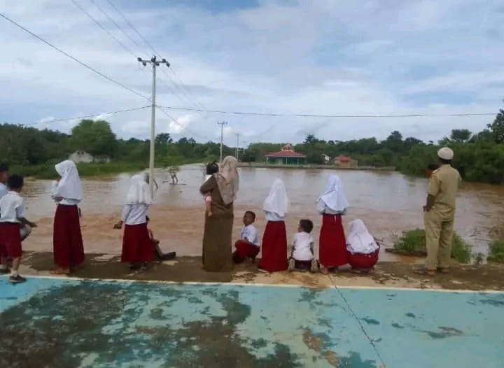 Guru dan murid SD Negeri 111 Sangia Makmur menyaksikan genangan air (banjir) di sekitar sekolah. Foto: Ist.