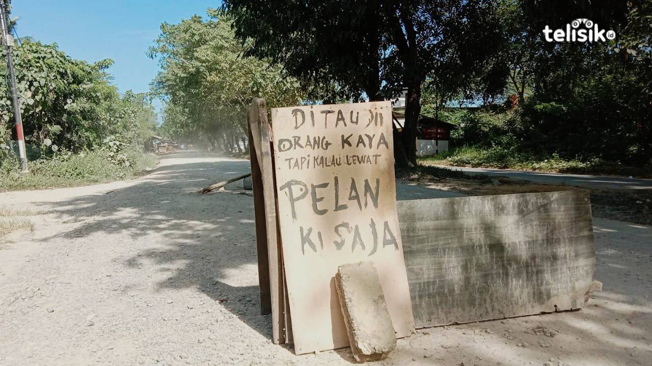 Masyarakat di sekitar jalan menuju Kebun Raya Kendari geram karena jalan rusak berat tak kunjung diperbaiki, memasang batu dan kayu di jalan sehingga pengguna jalan kesulitan melalui jalur tersebut. Foto: Rasmin Jaya/Telisik