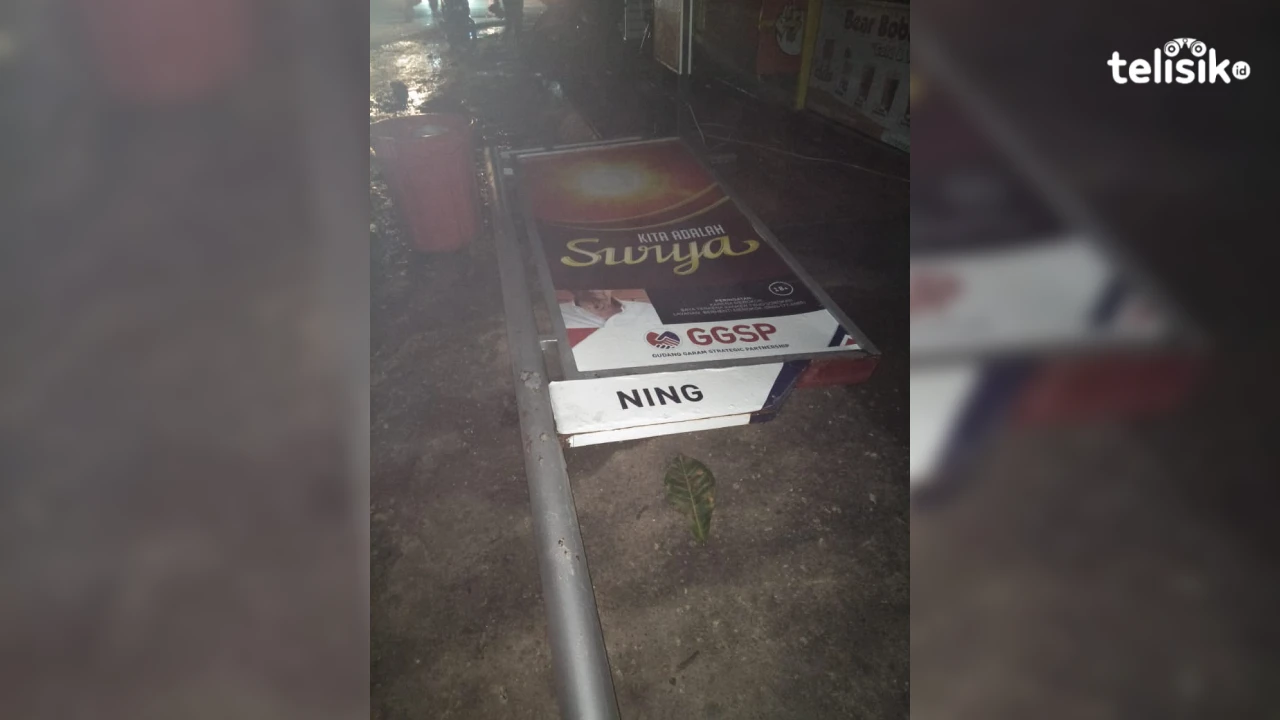 Papan reklame yang tumbang di perempatan Jalan Bunga Kamboja depan STIE 66. Foto: Thamrin Dalby/Telisik