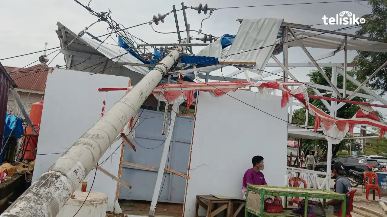 Tiang listrik menimpa Rumah Makan Bebek Sakti di depan RSUD Kota Kendari, Minggu (5/3/2023) sore. Foto: Rasmin Jaya/Telisik