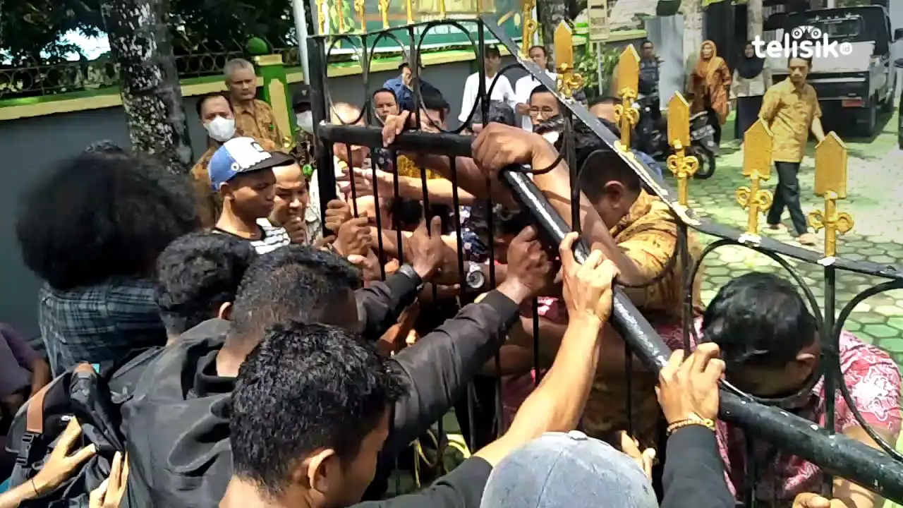 Massa aksi memaksa masuk ke halaman Pengadilan Negeri Kendari namun dihalangi oleh petugas dan pegawai PN Kendari. Foto: Thamrin Dalby/Telisik