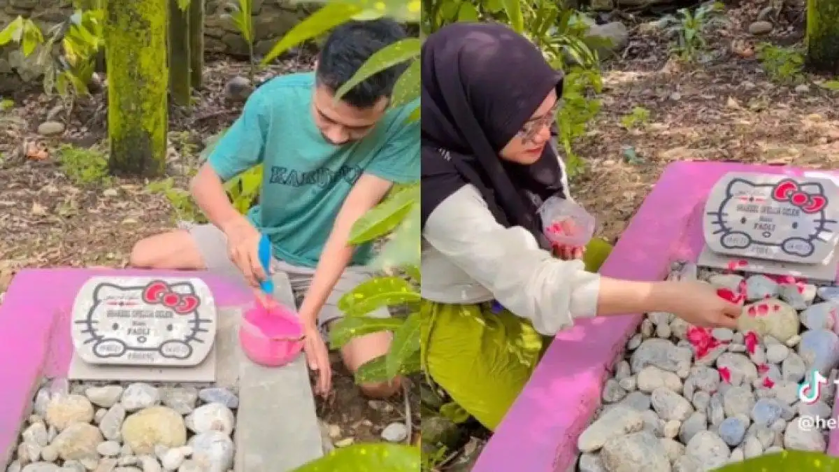 Tampak sang suami sedang mengecat warna pink untuk menghiasi makam buah hatinya. Terdapat pula hiasan karakter Hello Kitty pada nisan. Foto: Repro postingannews