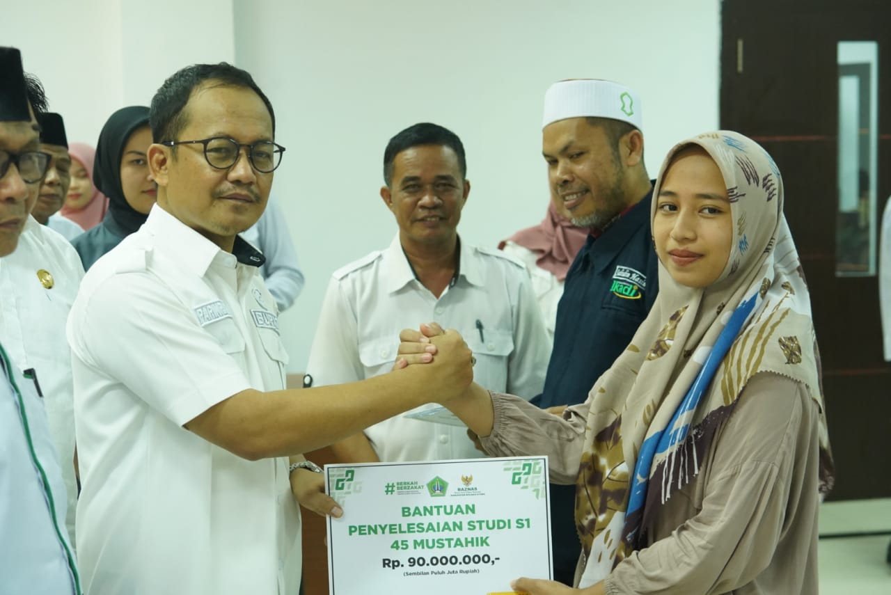 Penyerahan secara simbolis bantuan zakat profesi ASN yang dikelolah Baznas oleh Pj Bupati Kolaka Utara, Parinringi kepada salah satu perwakilan mahasiswa Kolaka Utara. Foto: Diskominfo Kolaka Utara