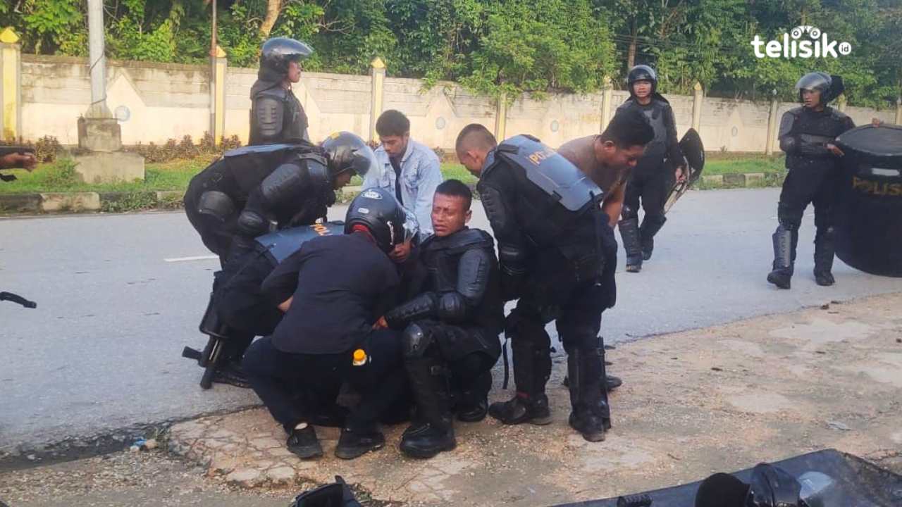 Seorang warga yang sedang dievakuasi karena mengalami sesak dan perih akibat gas air mata. Foto: Erni Yanti/Telisik