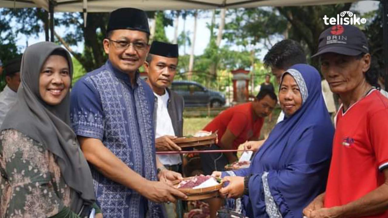 Pj Bupati Kolaka Utara, Parinringi menyerahkan daging kurban ke salah seorang warga menggunakan besek. Foto: Muh Risal H/Telisik