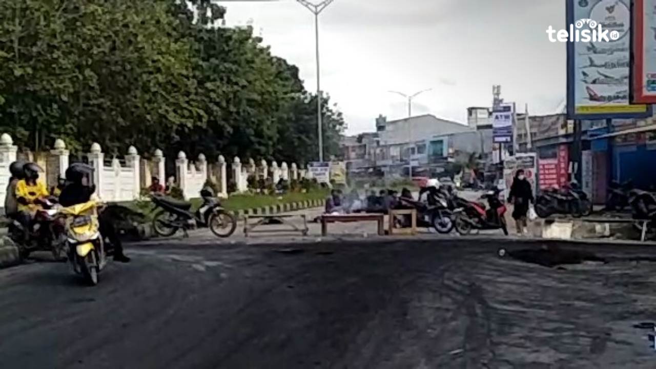 Massa yang usai dibubarkan paksa dengan menggunakan gas air mata, kembali melakukan pemblokiran poros jalan pertigaan UHO dan depan Lorong Salangga. Foto: Thamrin Dalby/Telisik