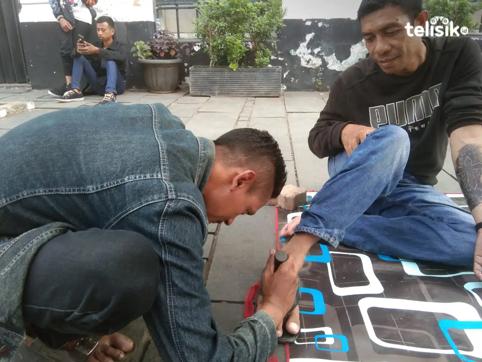 Taufan, pekerja seni dari Komunitas Lorong Rupa, melayani pelanggan di pelataran Museum Taman Fatahillah, Jakarta. Foto: Mustaqim/Telisik