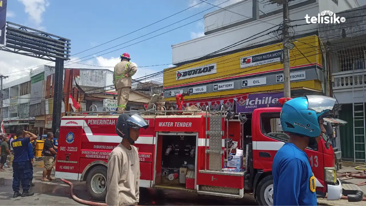 Mobil pemadam kebakaran berusaha memadamkan api di lantai 2 sebuah bengkel motor di Kendari. Foto: Ahmad Jaelani/Telisik