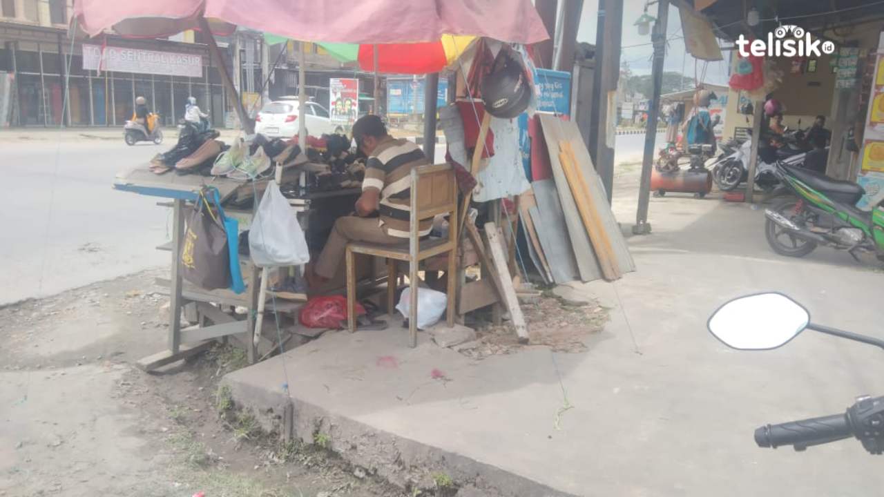 Tukang jahit sepatu yang sedang memperbaiki sepatu pelanggan di pinggir jalan, Foto: Merdiyanto/Telisik