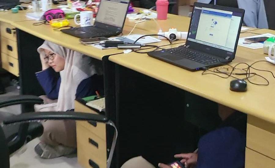 Pegawai Kanwil DJPb Kemenkeu RI Sulawesi Tenggara mengamankan diri di bawah meja saat terjadi bencana gempa. Seperti ini salah satu simulasi gempa yang dilakukan BPBD Kota Kendari. Foto: Ist.