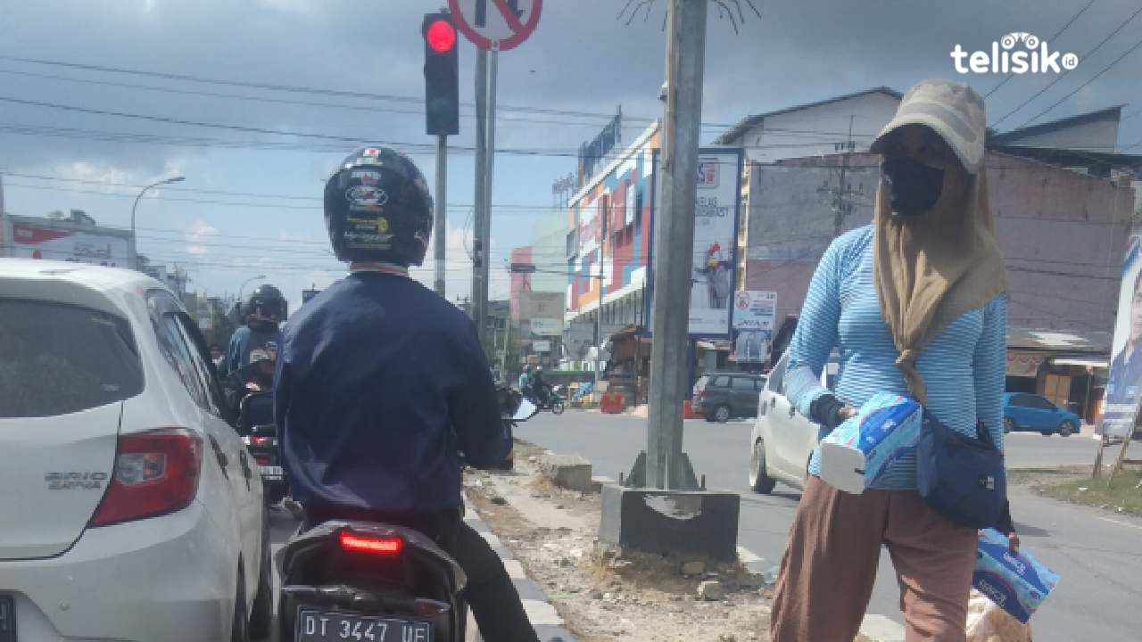 Pedagang kaki lima menjajakan jualannya di bawah cahaya lampu merah Kota Kendari. Foto:  Merdiyanto/Telisik 