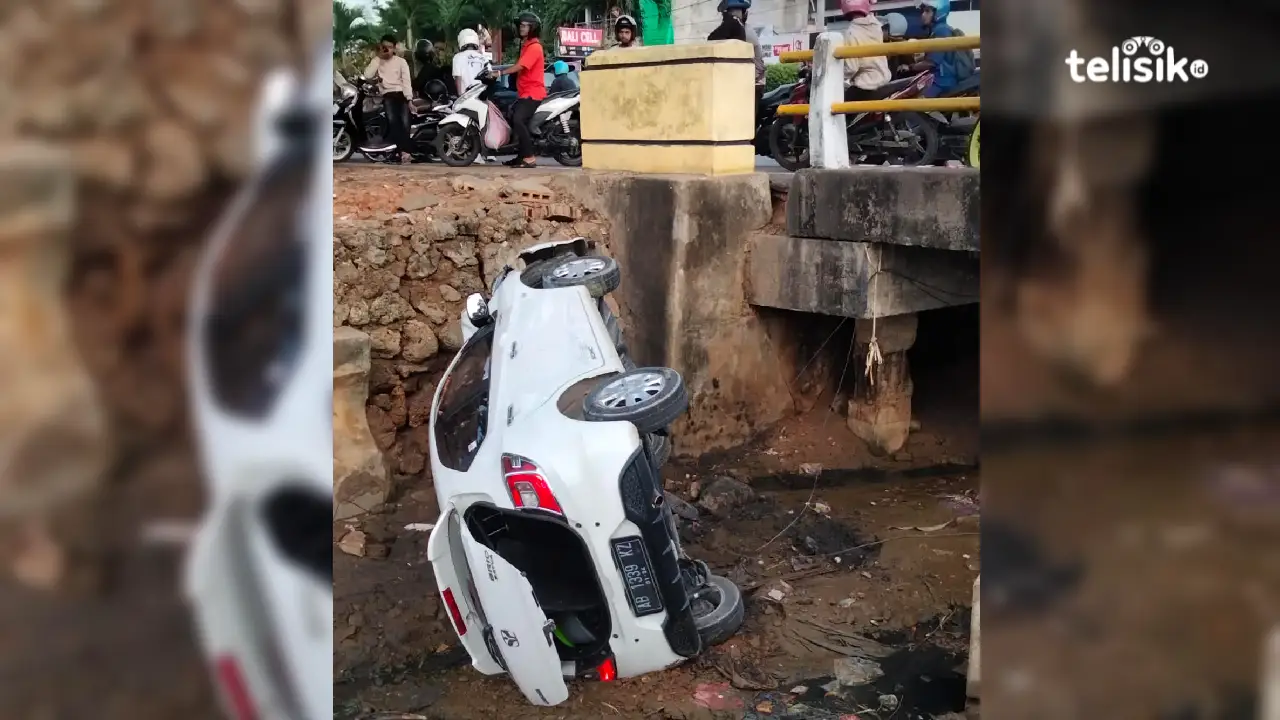 Mobil Honda Brio yang terjun di jembatan sekitar Anjungan Teluk Kendari, Jumat (22/12/2023) subuh. Foto: Thamrin Dalby/Telisik