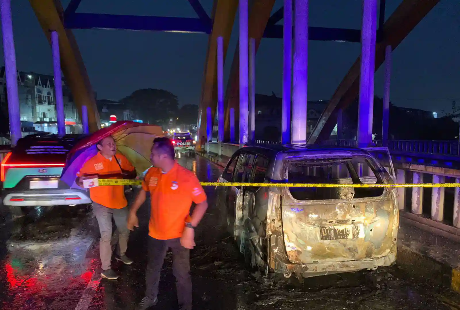 Petugas kepolisian melakukan olah TKP di jembatan pasar baru Kendari, lokasi kebakaran mobil Avanza. Foto: Ist.