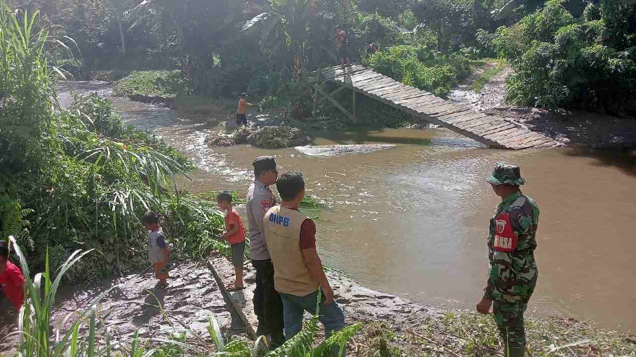Kepala BPBD Kolaka Timur bersama TNI-Polri saat meninjau lokasi jembatan yang patah akibat banjir. Foto: Ist.