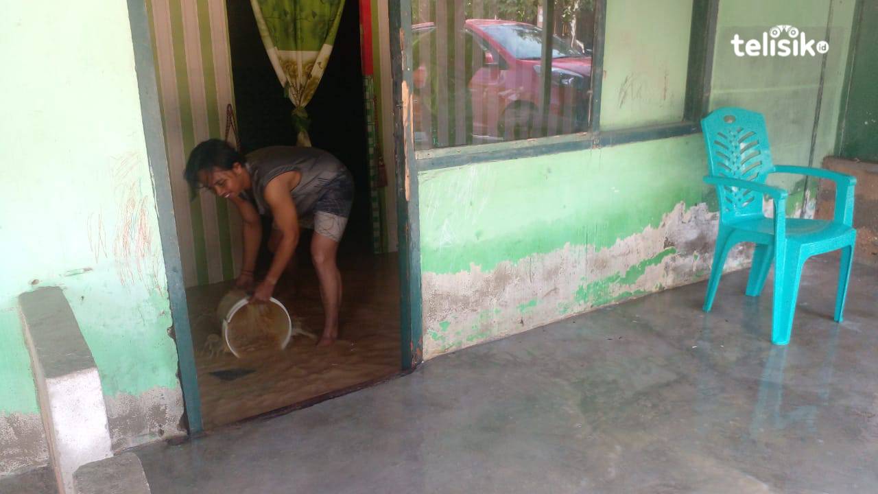 Warga sedang menguras air yang masuk ke dalam rumahnya setelah hujan deras Kamis (29/2/2024) dini hari. Foto: Nur Aziza/Telisik