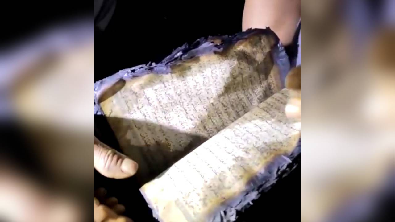 Penampakan Al-Qur'an yang utuh dan masih bisa terbaca, ditemukan di dalam rumah yang ludes terbakar. Foto: Screenshot video