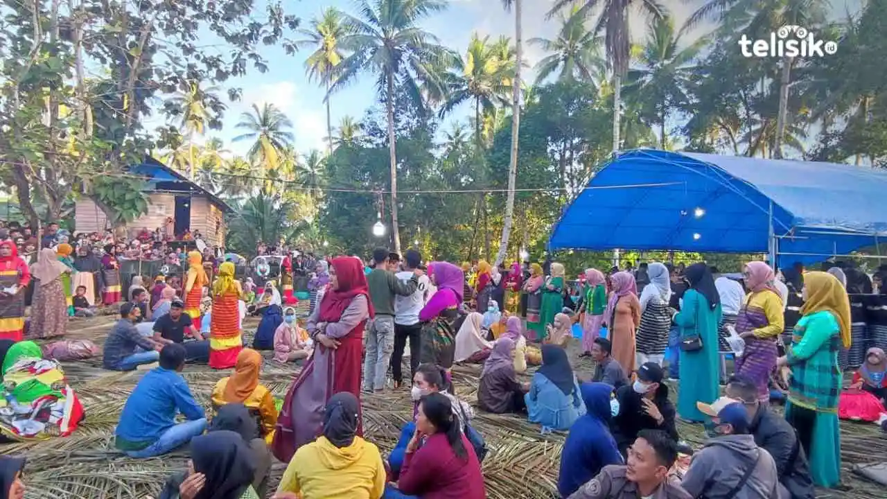 Masyarakat yang hadir dalam acara pesta panen (haroano laa) bersiap untuk berlomba mengambil makanan yang telah disajikan di dalam talang. Foto: Rina Gayatri/Telisik