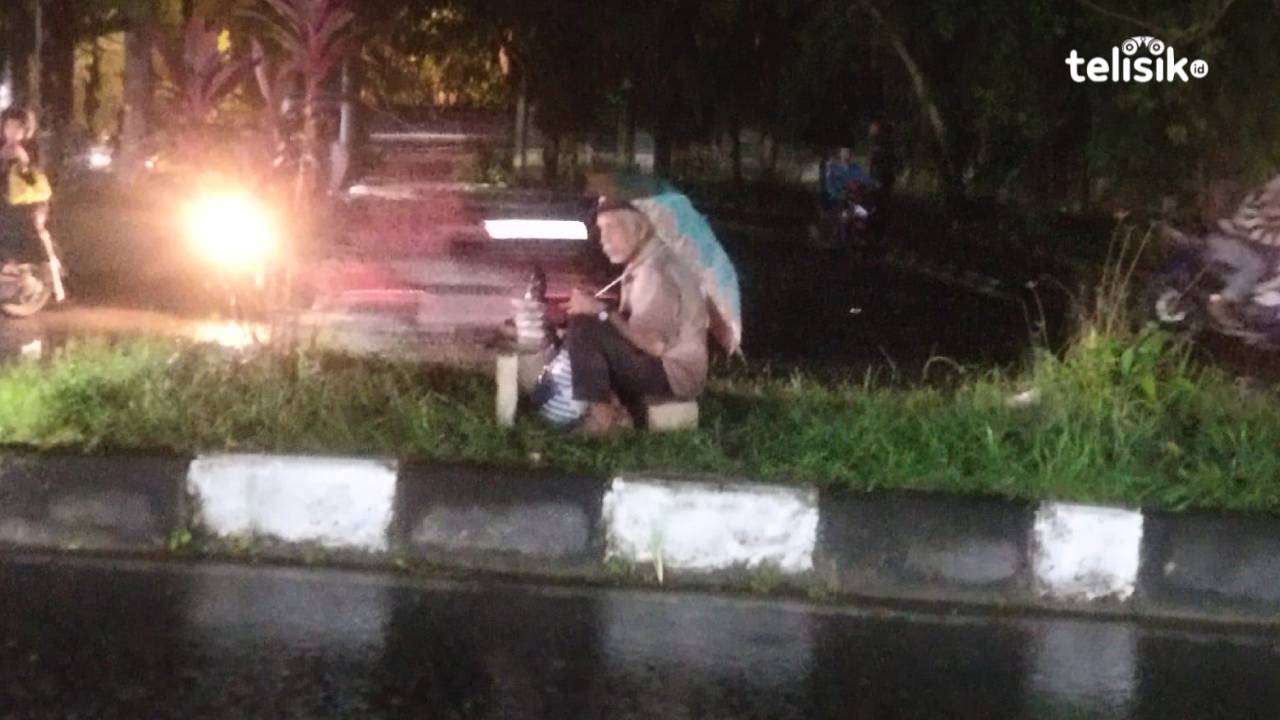 Kakek La Ria (70) dengan sabar menjajakan dagangannya di trotoar jalan depan kampus Universitas Halu Oleo (UHO). Foto: Erni Yanti/Telisik