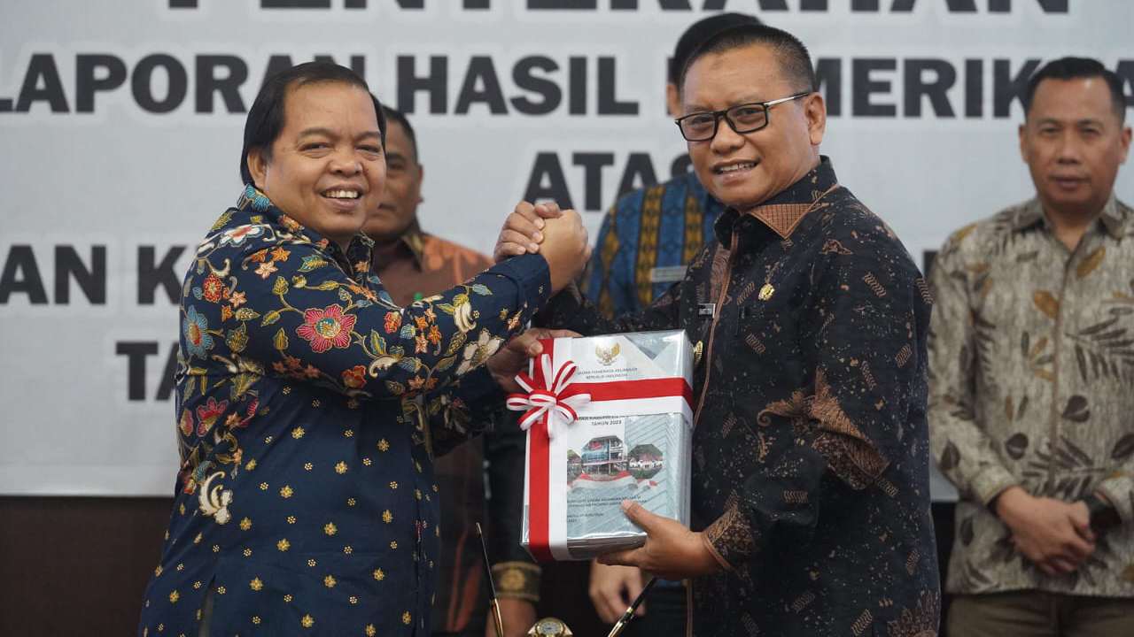 Pj Bupati Kolaka Utara, Sukanto Toding saat menerima penghargaan Opini WTP dari Kepala BPK RI Perwakilan Sulawesi Tenggara, Dadek Nandemar. Foto: Ist.
