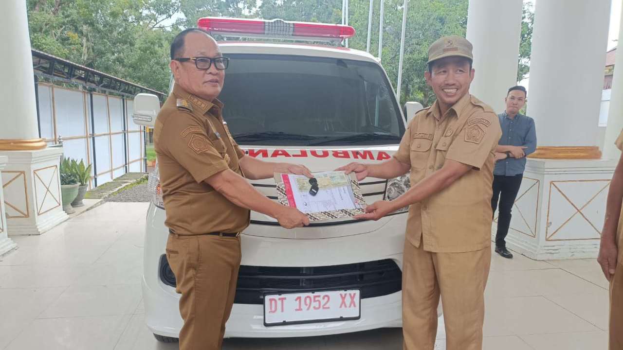 Pj Bupati Konawe saat menyerahkan mobil ambulance kepada Kepala Desa Barowila di depan Kantor Bupati. Foto: Ist.