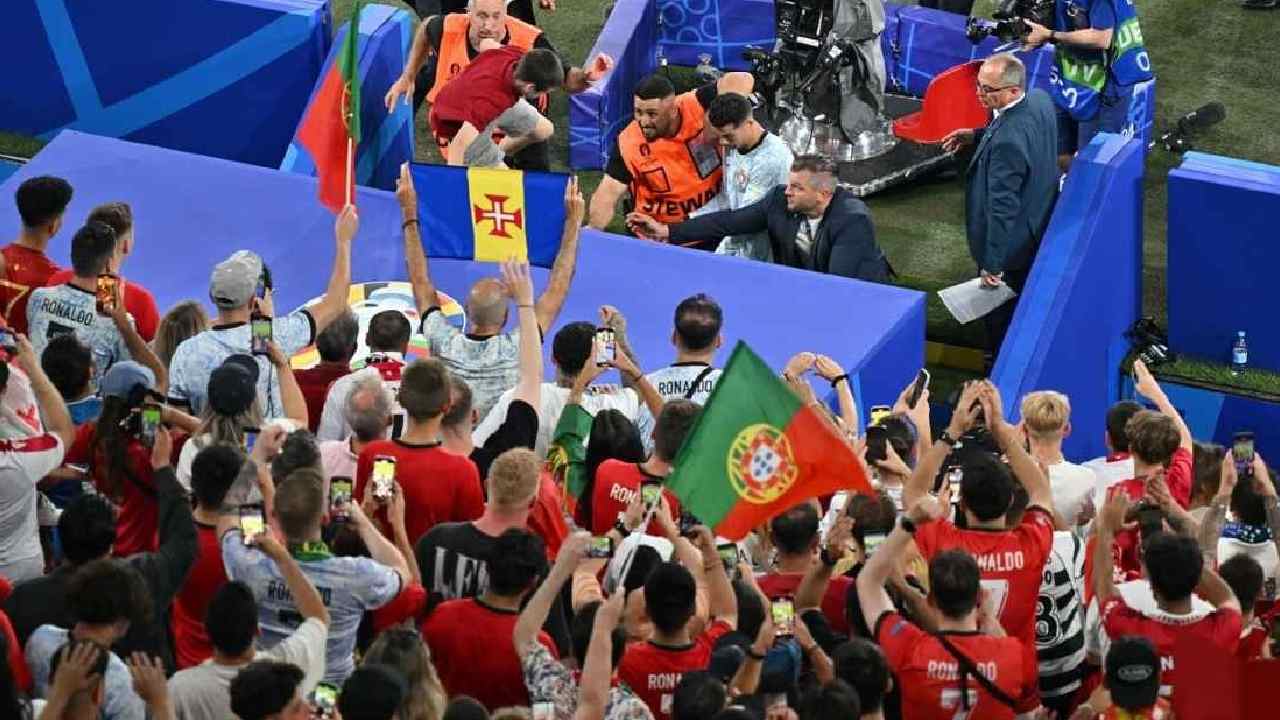 Seorang penggemar (kiri atas berbaju merah) yang melompat dari kerumunan berusaha memukul Cristiano Ronaldo setelah kekalahan Portugal dari Georgia pada Kamis (27/6/2024) dinihari WIB. Foto:Bernd Thissen/Getty Images