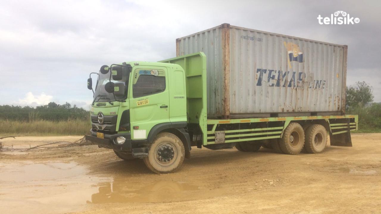 Mobil truk tronton melintasi jalan rusak dan berlubang dalam. Foto: Bambang Sutrisno/Telisik